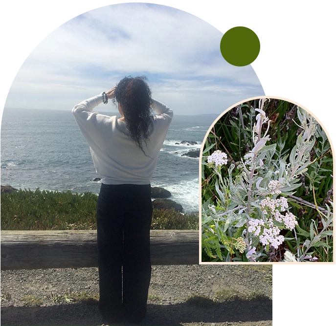 A woman standing on the side of a road near the ocean.